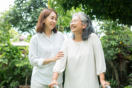 a young woman and elderly grandmother enjoy a sunny day in a lush garden