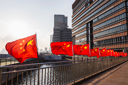 Row of Chinese flags on Huangpu river promenade, Shanghai, China