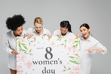 amazed woman pointing at huge womens day greeting card