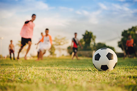 Children playing soccer football on field