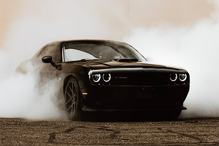 A luxury black car on the highway on a sunny day