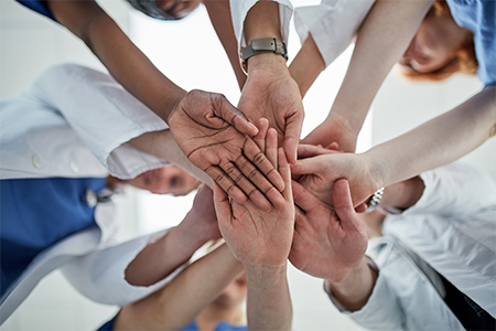 Low angle view of team members forming a hand stack