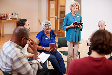 People Attending Bible Study Or Book Group Meeting In Community Center