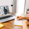 An African-American man conducts meeting on the laptop screen indoor