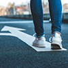 walking on directional sign on asphalt road, Female legs wearing jean