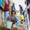 A diverse group of happy volunteers cleaning up street, community service concept
