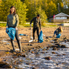  Volunteers are cleaning garbage in bag at beach on sunny day