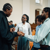 Priest praying with a family in church