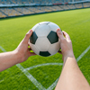 person holding soccer ball on soccer field stadium