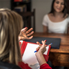 young woman talking to a person in consultation over desk in office