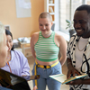 Happy young African American man with open notepad during discussion