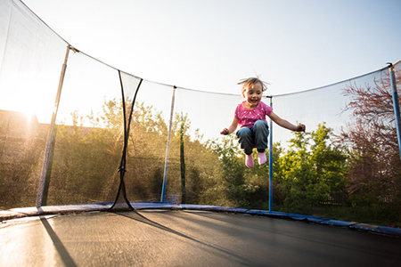 little kid jumping high on trampoline