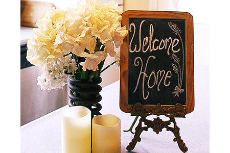 Welcome home chalkboard sign on the table with white flowers