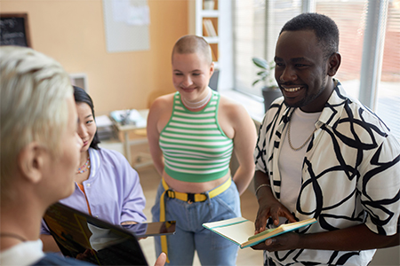 Happy young African American man with open notepad during discussion