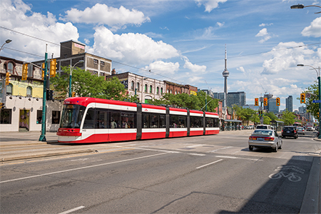 A view of cars and a subway in the streets of Toronto, Canada