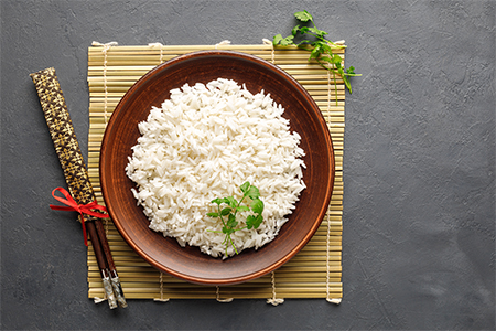 Top view of Boiled rice, chopsticks and bamboo napkin