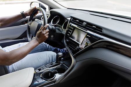 driver holding hands on steering wheel