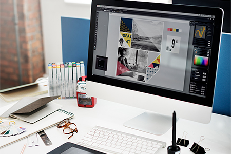 Designer is working on a drawing tablet and Desktop