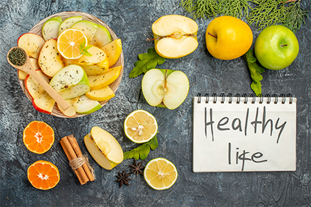 Vertical view of notebook with healthy life and collection of fresh natural organic apple slices on 