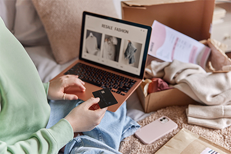 person holds banking card and uses laptop computer makes shopping online