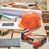 Orange protective helmet and builder instruments outside