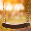 Empty children swing at sunset time closeup