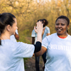 Team leader sharing a high five with her colleague, praising each other and feeling pleased