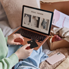 person holds banking card and uses laptop computer makes shopping online
