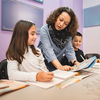 Female teacher helping elementary students