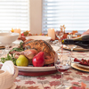 roasted turkey on a platter garnished with fresh herbs and fruit