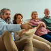 Four of senior friends siting on the couch in the living room and watching tv