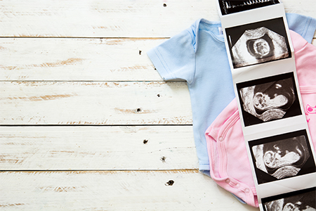 Pink and blue baby clothes waiting for new baby arrival