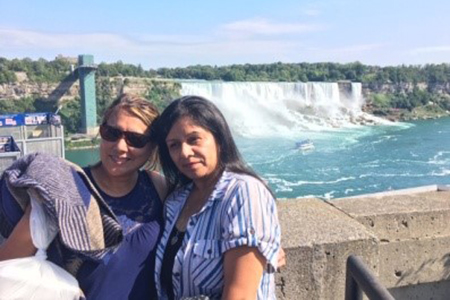 two women posing for photo in front of niagara falls