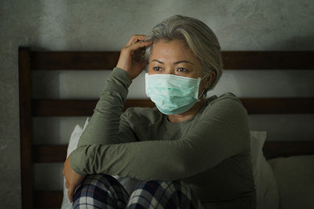 worried middle aged woman 50s with grey hair and protective mask during covid-19