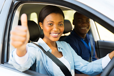 learner driver with instructor giving thumb up