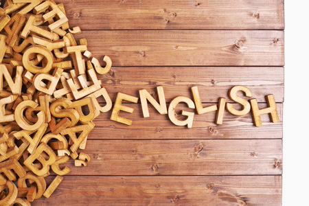 wooden board with wood pine block letters spelling out English