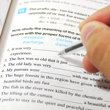 image of a person's hand completing an english exercise in book
