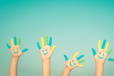 Happy people with smiley on hands against blue summer sky background
