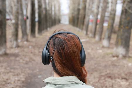 woman in woods with headphones on 