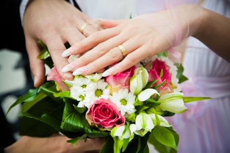hands of newly married with wedding bouquet