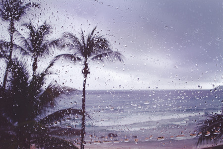 Blur background tropical island storm rain on window pane