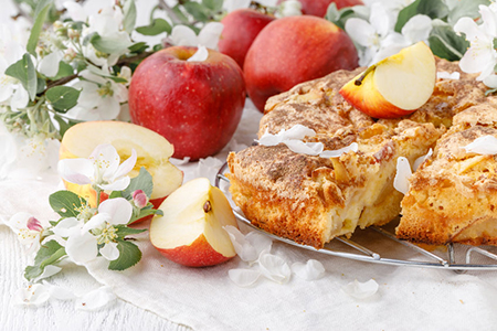 Freshly baked Apple pie on the table with apples, piece in plate