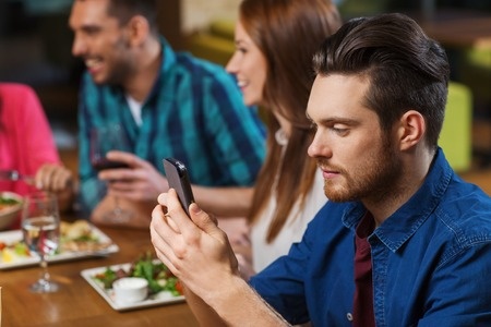 man on phone at dinner table
