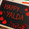 Happy Yalda night. Iranian traditional holiday. Pomegranate inscription on blackboard, flat lay.