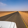 Straight as a die, gray asphalt road through the desert of Sudan-