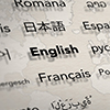 Several important languages on paper with world map background. Depth of field image. Translate and 