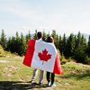 Couple with large Canadian flag celebration in mountains