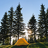 Tourist camping tent on mountain campsite at bright sunny evening