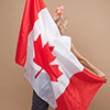 Beautiful asian woman, a sports fan, standing in front of a Canadian flag