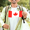Male tourist with flag of Canada in park